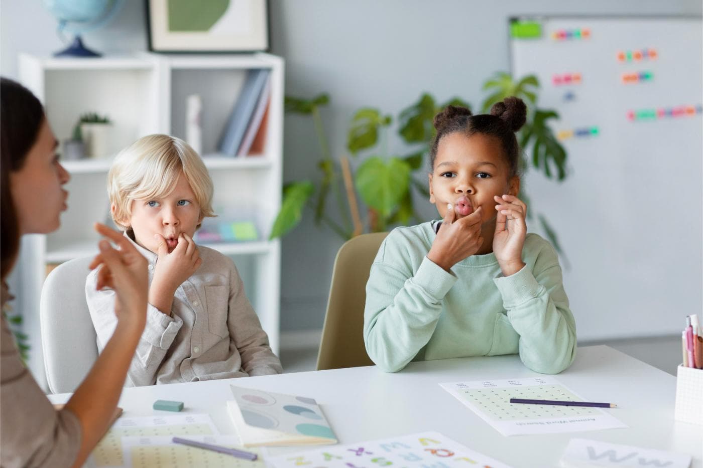 Child practicing speech sounds with a therapist
